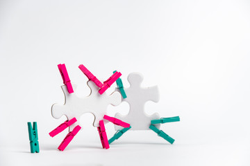 element of a clean puzzle with attached paper clips in the same color and one in a different color