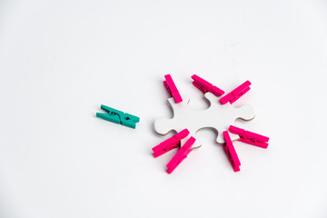 element of a clean puzzle with attached paper clips in the same color and one in a different color