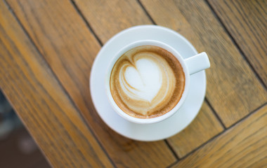 Cup of cappuccino coffee on wooden table. Copy space beside. Wooden table background. Top view.
