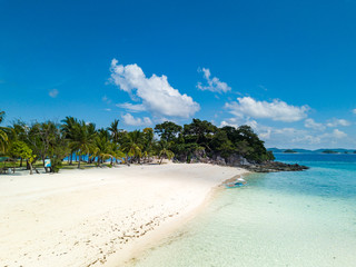 Aerial view of tropical beach on the island Malcapuya. Beautiful tropical island with sand beach, palm trees. Tropical landscape with shore and boat. Palawan, Philippines