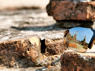 The reflection on a traveller's sunglasses at The Wat Mahathat, Ayutthaya, Thailand. This place also be one of ayutthaya historical park.