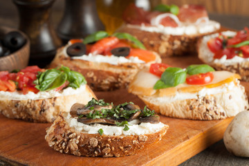 Italian tomato and cheese bruschetta. Tapas, antipasti with chopped vegetables, herbs and oil on grilled ciabatta and baguette bread.