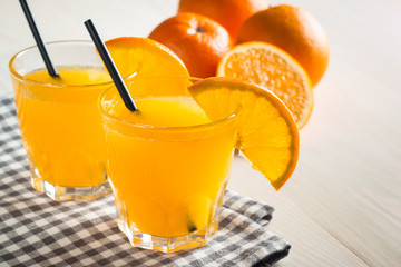 Photo of fresh orange juice in the glass jar. Summer healthy organic drink concept. Cold beverages with ice and orange fruits.