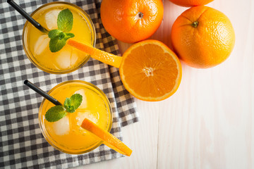 Photo of fresh orange juice in the glass jar. Summer healthy organic drink concept. Cold beverages with ice and orange fruits.