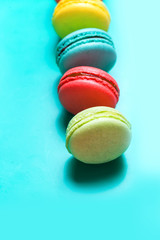 Cake macaron or macaroon on turquoise background, pastel colors