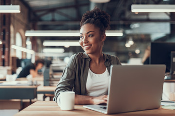 Beautiful afro american lady working at modern office - Powered by Adobe