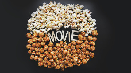 Popcorn on black background. Watching a movie with popcorn. Copy space