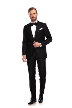 handsome businessman standing and buttoning black suit