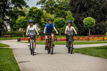 Healthy lifestyle - people riding bicycles in city park