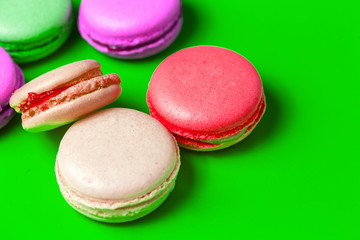 Closeup of colorful pink, purple macaroon on green background
