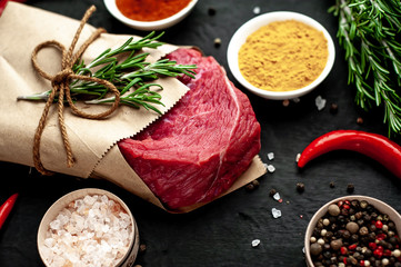 meat from a butcher shop, wrapped in paper. A piece of beef on a concrete black background