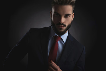 portrait of seductive businessman wearing navy suit and red tie