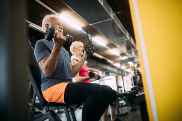 Happy fit mature man in gym working out to stay healthy