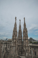 Fototapeta premium Roof terraces of gothic Milan Cathedral, or Duomo di Milano, at sunset. The beautiful gothic cathedral is the main tourist attraction of Milan, Lombardy, Italy