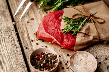 meat from a butcher shop, wrapped in paper. A piece of beef on a wooden background