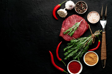 meat from a butcher shop, steak with ingredients. A piece of beef on a concrete black background