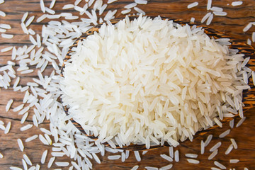Rice seeds are stacked on a ladle. Lay on the wooden floor Jasmine Rice.