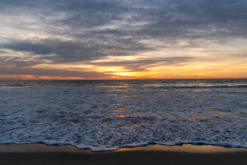 View of sea and waves at sunset
