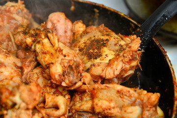 Fried chicken with spices in a pan