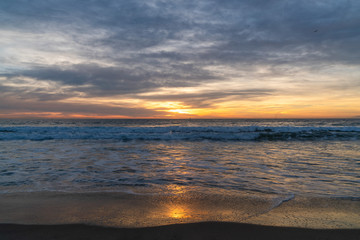 View of sea and waves at sunset