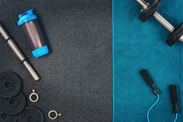 Fitness or bodybuilding concept background. Product photograph of old iron dumbbells on black grey, conrete floor in the gym. Photograph taken from above, top view with lots of copy space