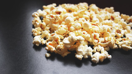 Heap of classic salty popcorn on black background. Concept cinema or food