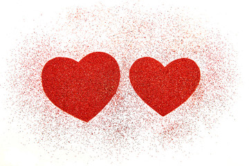 Two red hearts with sequins on white background