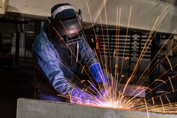 Industrial worker is welding repair steel part