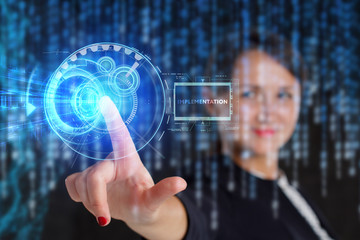 The concept of business, technology, the Internet and the network. A young entrepreneur working on a virtual screen of the future and sees the inscription: Implementation