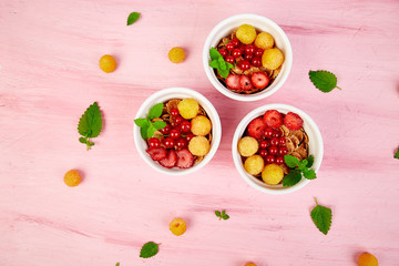 Healthy breakfast on white bowls. Fresh granola, muesli or cereal with berries