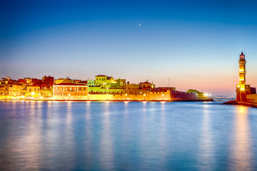 Fototapeta na wymiar Night Panorama of Old Venetian City of Chania Taken at Blue Hour from Pier with the Lighthouse in Background.