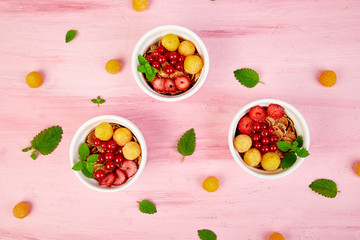 Healthy breakfast on white bowls. Fresh granola, muesli or cereal with berries