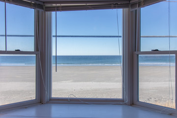 box bay window overlooking beautiful beach with no one on it