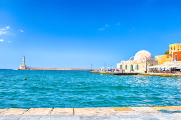 Fototapeta na wymiar Travel ideas. Chania Old Port and Venetian Harbor With Ancient Lighthouse on Background.