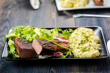 Beef steak with mashed potatoes and rocket salad
