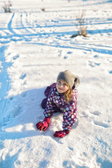 young girl is fooling around on the snow