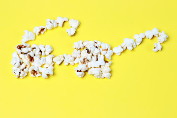 popcorn laid out in the form of glasses on a yellow background close-up, top view