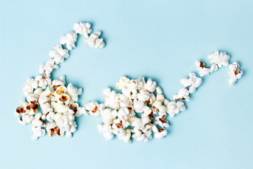 popcorn laid out in the form of glasses on a blue background close-up, top view