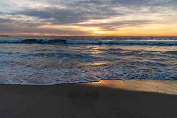 View of sea and waves at sunset