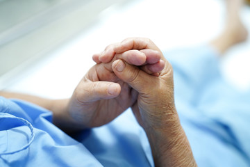 Asian senior or elderly old woman patient pain finger and hand while sitting on bed in nursing...