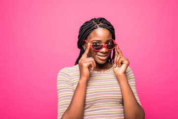 Excited girl with pleasure and expressing truly emotions holding hersunglasses isolated on pink background.