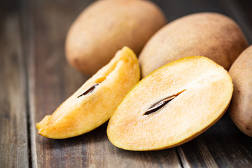 Sapodilla plum fruit on wooden table, exotic Thai fruit (La mood)