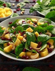 Mango Spinach salad with dried cranberries and nuts. healthy food.