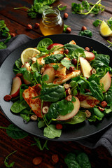 Grilled Halloumi Cheese salad with peach fruit, nuts and spinach, arugula mix. healthy food