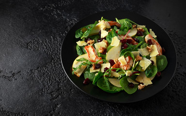 Pear, chicken salad with cheddar cheese, cranberry and walnuts. healthy food. black stone background
