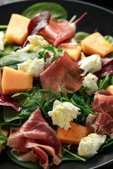 Parma ham and melon salad with mozzarella, green leaves mix