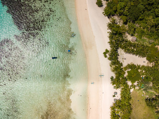 Aerial top view of tropical beach on the island Malcapuya. Beautiful tropical island with sand beach, palm trees. Travel tropical concept. Palawan, Philippines