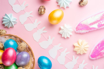 Easter holiday background. Easter eggs colored with rabbit ears on a pink background, horizontal composition. Greeting card concept