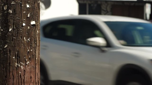Street scene backplate with foreground in focus and background soft for keying in talent includes wooden utility pole with staples and traffic.