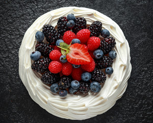 Berry Pavlova cake with fresh blueberries, strawberries and raspberries